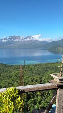 Vertical shot of active Mount Lewotobi twin volcano in East Flores Indonesia seen from a wooden terrace balcony
