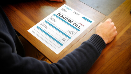 Fototapeta premium A Stressed Homeowner looks at a Electrical Bill