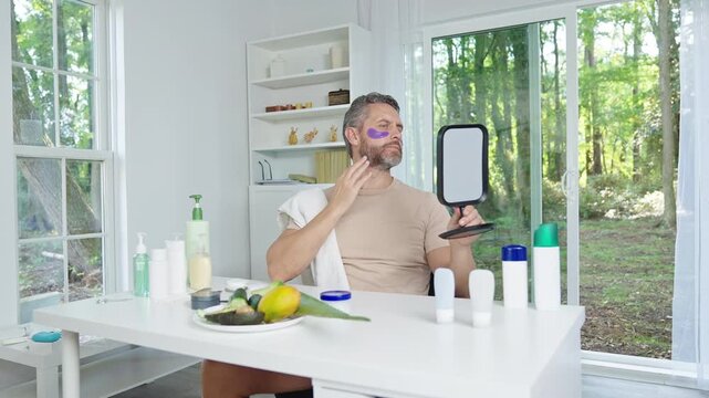 Male cosmetology treatment with under eye patches. Eye patch care for healthy and refreshed skin. Male beauty concept with eye patch application. Under eye patches reducing signs of aging.