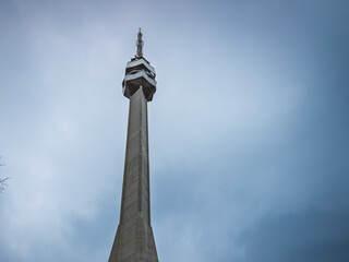 Obraz premium A towering view of the Avala Tower’s concrete structure near Belgrade, Serbia, captured from below against a softly lit sky. It is a TV tower and broadcasting antenna in suburbs of Belgrade, Serbia