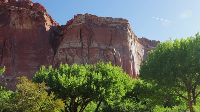 An airplane contrail, or condensation trail, passes over the historic Fruita district in Capitol Reef NP - Part 1 of 2