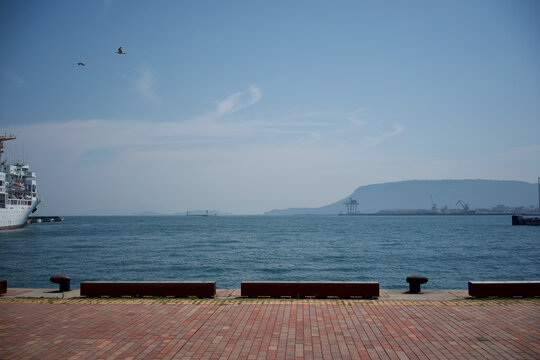 Panoramic harbor view of Takamatsu with a passenger ship and mountains under clear blue sky