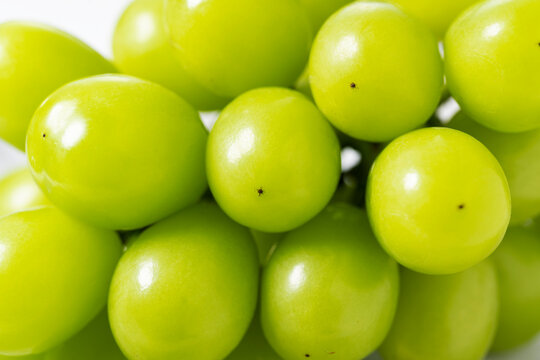 Shine Muscat grapes on a white background.