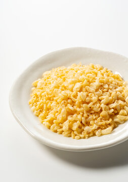 Tenkasu served on a plate placed on a white background.