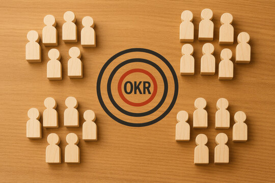 Wooden team figure arranged around target with OKR text representing objective key result alignment and organizational department structure on warm wood surface