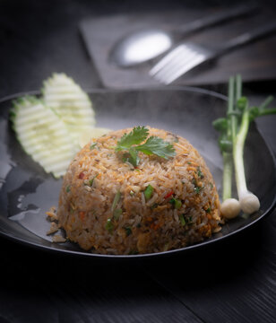 Thai style fried rice with egg served on black plate close up.