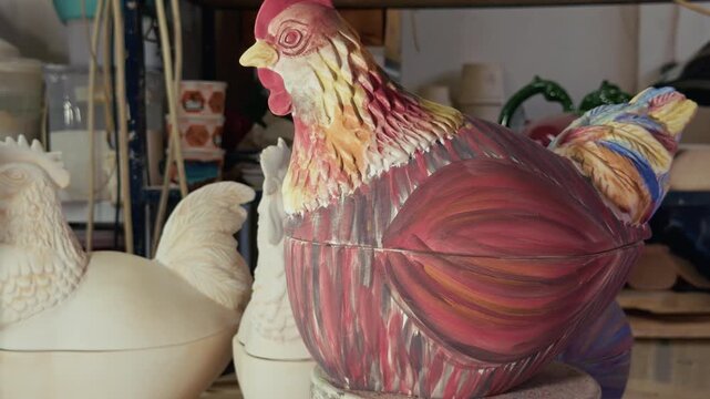 Artisan Painting Ceramic Chicken Figurine With Brush In Pottery Workshop