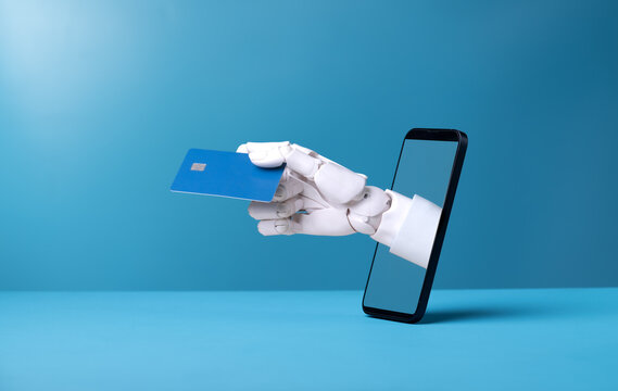 Robotic hand holding blue credit card emerging from smartphone screen.
