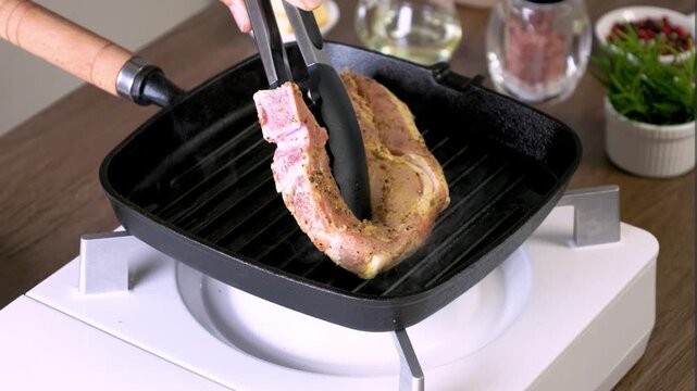 A thick pork chop is grilling until the skin is a beautiful golden color. The aroma of meat and spices fills the air. Every bite is juicy and delicious, ready to satisfy steak lovers.