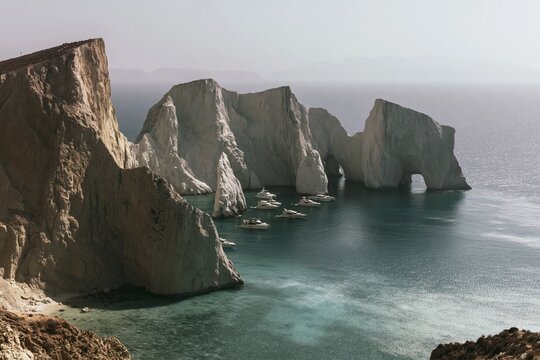 Towering white sea stack formations and limestone cliffs rising from a turquoise bay for luxury yacht charter, adventure travel and summer vacation
