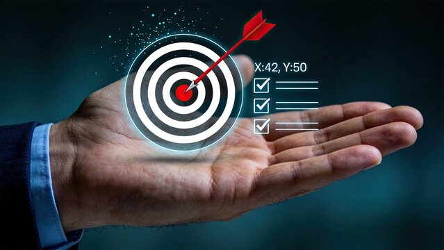 Hand holding virtual target with red arrow hitting bullseye, symbolizing business goal achievement, success strategy, precision marketing and accurate planning concept on dark
