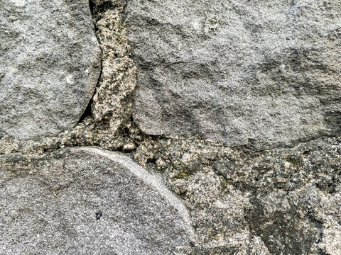 Natural stone wall texture with rough surface and weathered rock pattern. Suitable for construction, architecture, exterior design, and background applications.