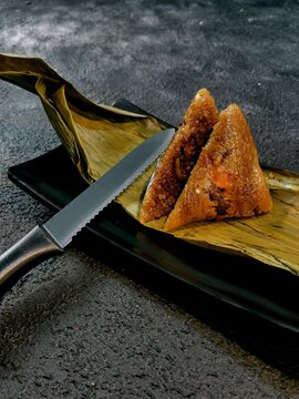 Bacang is a traditional Chinese food wrapped in bamboo leaves filled with glutinous rice with soy sauce pork or chicken, salted egg, and sometimes mushrooms or peanuts.