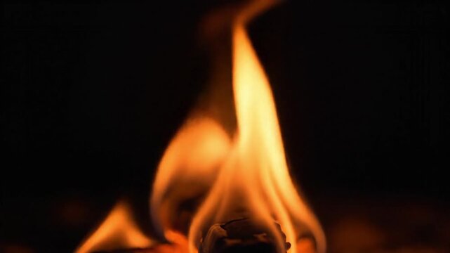 Dynamic close up footage of bright orange flames flickering and dancing in slow motion 4k video