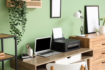 Fototapeta premium Workplace with modern printer and laptop in stylish home office, closeup