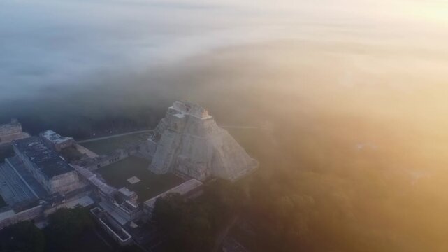 Aerial view of Uxmal pyramid in sunrise fog.