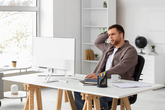 Portrait of confused male programmer working in office