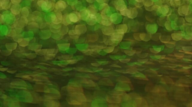 Hypnotic glow. Blur sparkle. Defocused light transition spin optic stroboscopic lens. Green yellow rays bokeh color reflection abstract background.