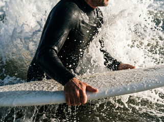 Fototapeta premium Man in wetsuit surfing ocean waves.
