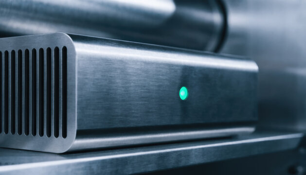 Modern metal electronic device with green indicator light represents ai governance and ot security in technology systems