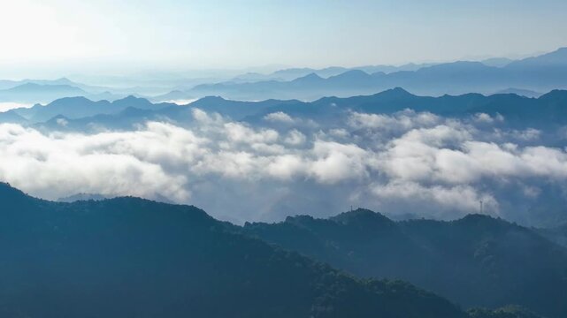 Misty layered mountain ridges above clouds at dawn