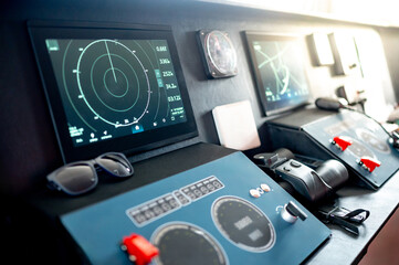 Digital dashboard with navigation monitor system, marine radar, VHF Radio and binoculars in ship captain bridge. Wheelhouse steering console on Nautical vessel transport. Modern boating technology © zephyr_p