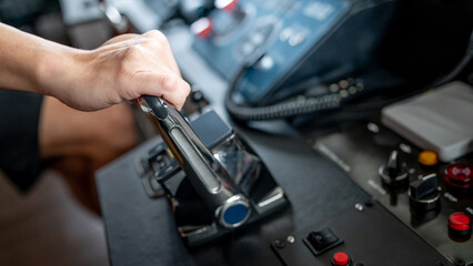 Captain hand holding throttle control or engine control lever on modern boat dashboard in wheelhouse or ship bridge. Speed adjustment instrument for seafaring technology © zephyr_p