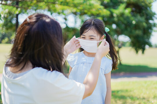 子どもにマスクを付けさせるお母さん