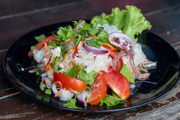 Thai spicy and sour glass noodle with seafood salad on black plate, called Yam Woon Sen Talay or Yum Wun Sen Talay. Close up © Lyudmila