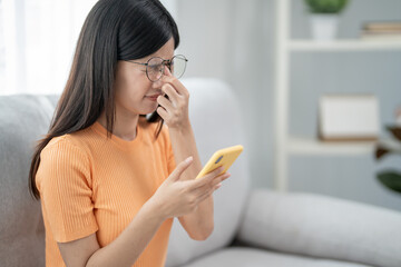 Fototapeta premium Eye problems, Asian women use hand cover eyes due to eye irritation, eye rubbing, dry, eye pain after look mobile phone long time, migraine, headache, blurred vision, photophobia, small words