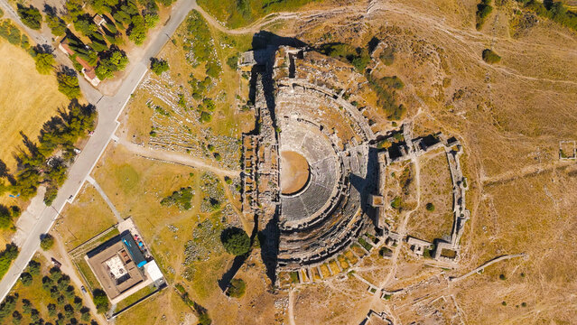 Balat, Turkey. Aerial drone view of the ancient Theatre of Miletus on its hill and the historic Ilyas Bey Caravanserai in front of it. Aerial View