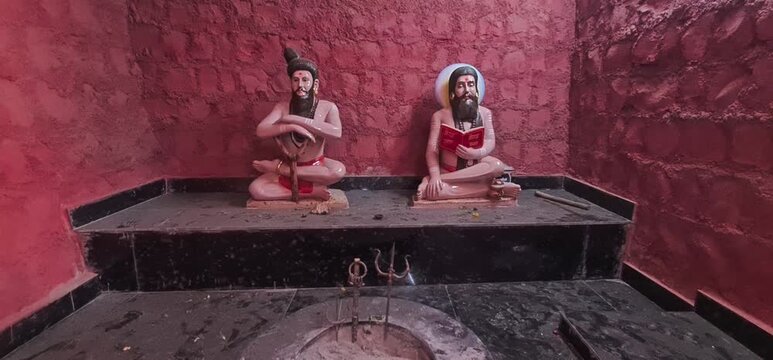 Traditional Hindu Monk Sculptures Seated Near a Holy  Fire Pit in Red Rock Cut Cave Shrine, Ujjain, Madhya Pradesh 