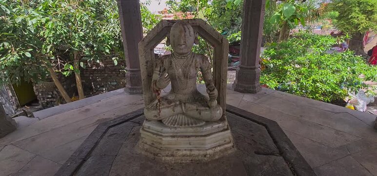 Weathered Marble Deity Statue Sitting in Meditating Posture Near Ram Ghat in Ujjain