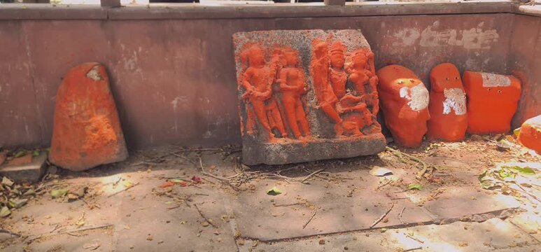 Orange Painted Stone Deity Sculptures and Relics Kept on the Ground at Ujjain Temple Complex