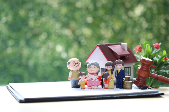 Family estate planning and legacy concept with multigenerational figures, house model, gavel, and coins on contract document, symbolic of legal property rights and inheritance management.