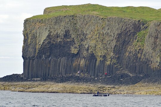 A coastline with prominent basalt cliffs and green grassland above, Hebridean Overture, Isle of Staffa, Inner Hebrides, Scotland, United Kingdom
