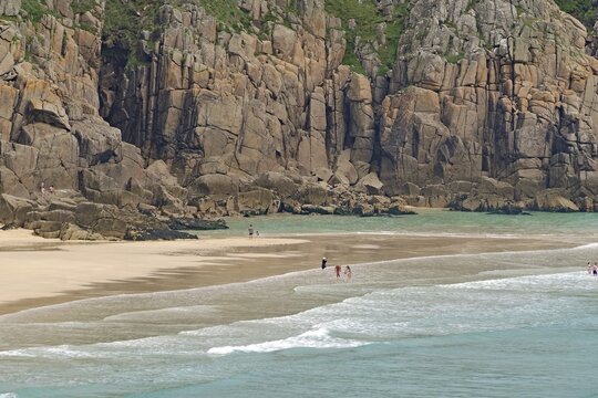 Sandstrand mit hohen Klippen und ruhigem t&uuml;rkisfarbenem Meer, wenige Menschen, Porthcurno, St Levan, Cornwall, Gro&szlig;britannien
