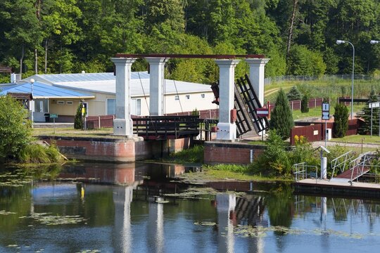 Lock bridge with neighbouring building in the countryside on a summer's day, Śluza Kurzyniec, Sluza, lock, border between Belarus on the left and Poland on the right, Kanał Augustowski, Augustow Canal, Rudawka, Płaska, Plaska, Powiat Augustowski, Podlaskie, Podlaskie, Poland