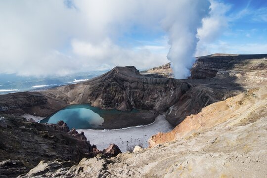 Steaming fumarole with crater lake on the Gorely volcano, Kamchatka, Russia
