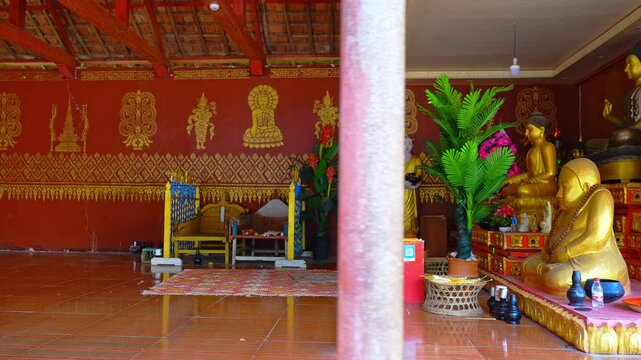 Buddhist temple interior with golden Buddha statues and ornate red walls