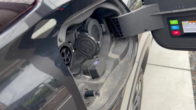電気自動車の充電プラグを取る手元