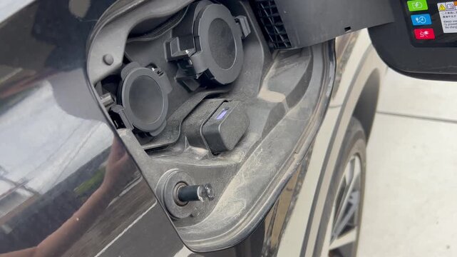 電気自動車の給油口を開ける手