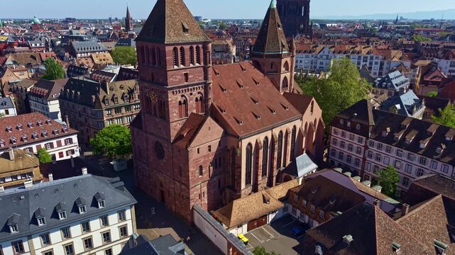 Upward drone fly near the gothic protestant St Thomas' Church with Strasbourg Cathedral and European Parliament in background, Strasbourg, Petite France, France