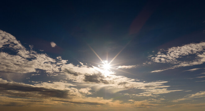 Sun in sky background. Sun rays on cumulus clouds. Sun bright daylight. Sun glowing air.
