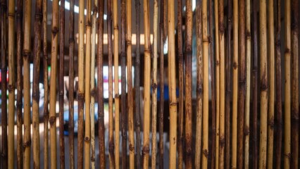 Obraz premium Vertical bamboo rods forming semi transparent market partition