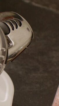 Vertical video: Entering hand passing over chrome head on countertop, moving clear jar, copy space