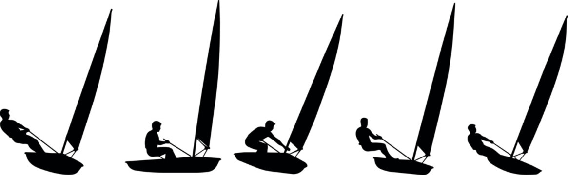 Silhouettes of sailors on windsurf boards in motion across the water