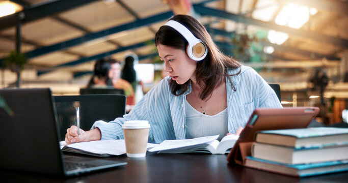 Woman, student and writing with headphones in library or university study for education or learning. Female person, academic learner or listening with book for audio translation or online assignment