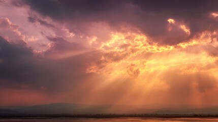 Obraz premium Golden sunbeams piercing a clouded sky at sunset over a tranquil landscape, evoking faith and optimistic futures