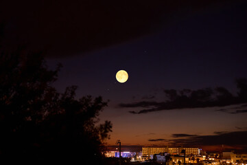Obraz premium Full Moon with urban silhouettes.